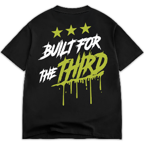 A black t-shirt featuring bold white and neon green text on the back that reads BUILT FOR THE THIRD, accompanied by three stars above the text. The design has a graffiti-style drip effect, adding a streetwear aesthetic.